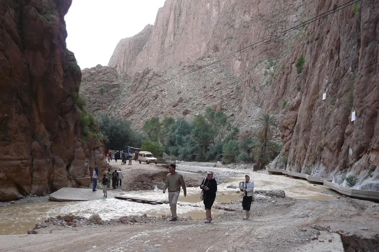 Walkers on the road between the sheer walls of the Todra Gorge